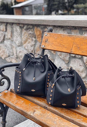 Two bucket bags on a park bench